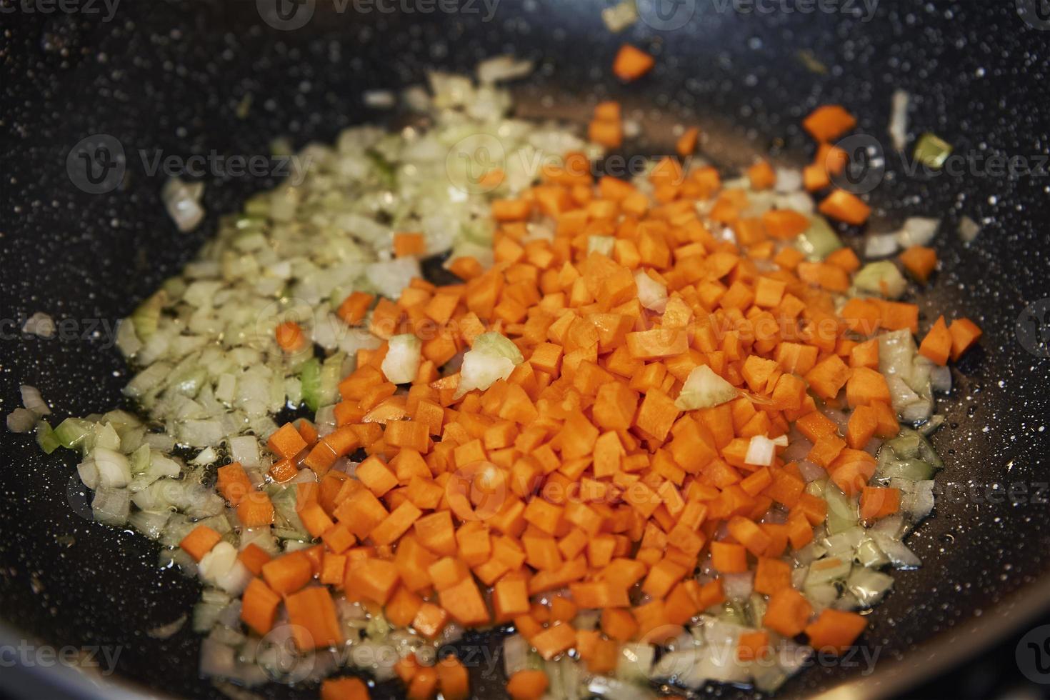 Frying vegetables for cooking sauce bolognese in kitchen photo