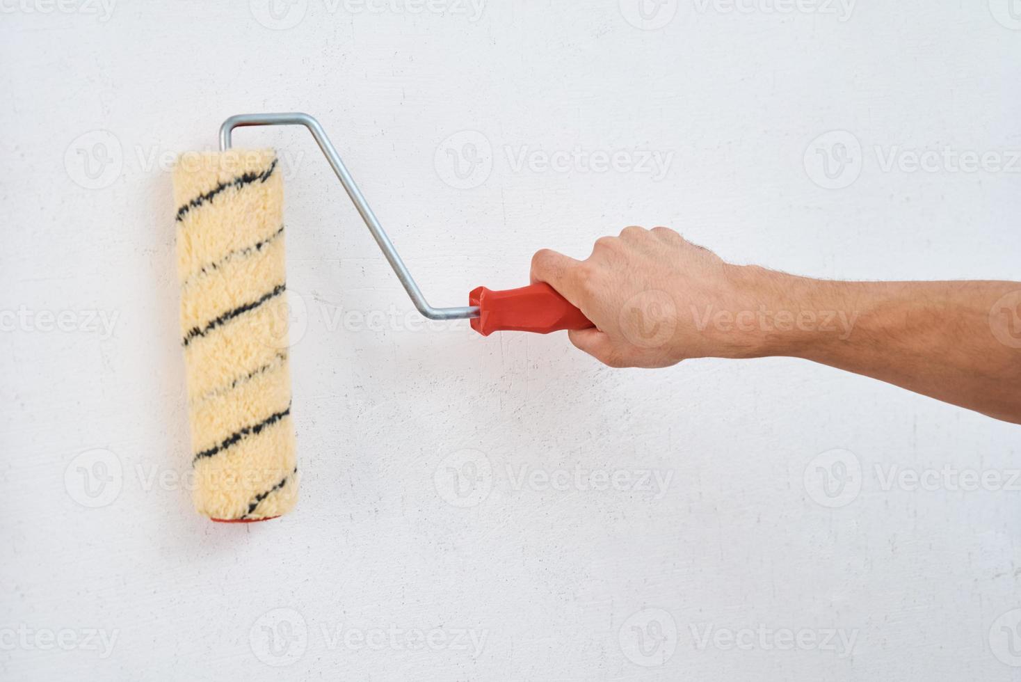 Man painting wall with paint roller photo