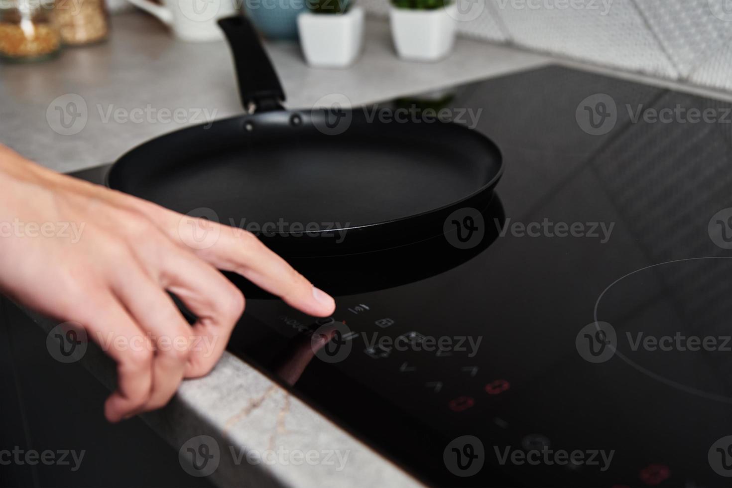 Woman hand turns on modern induction stove in the kitchen 18911507
