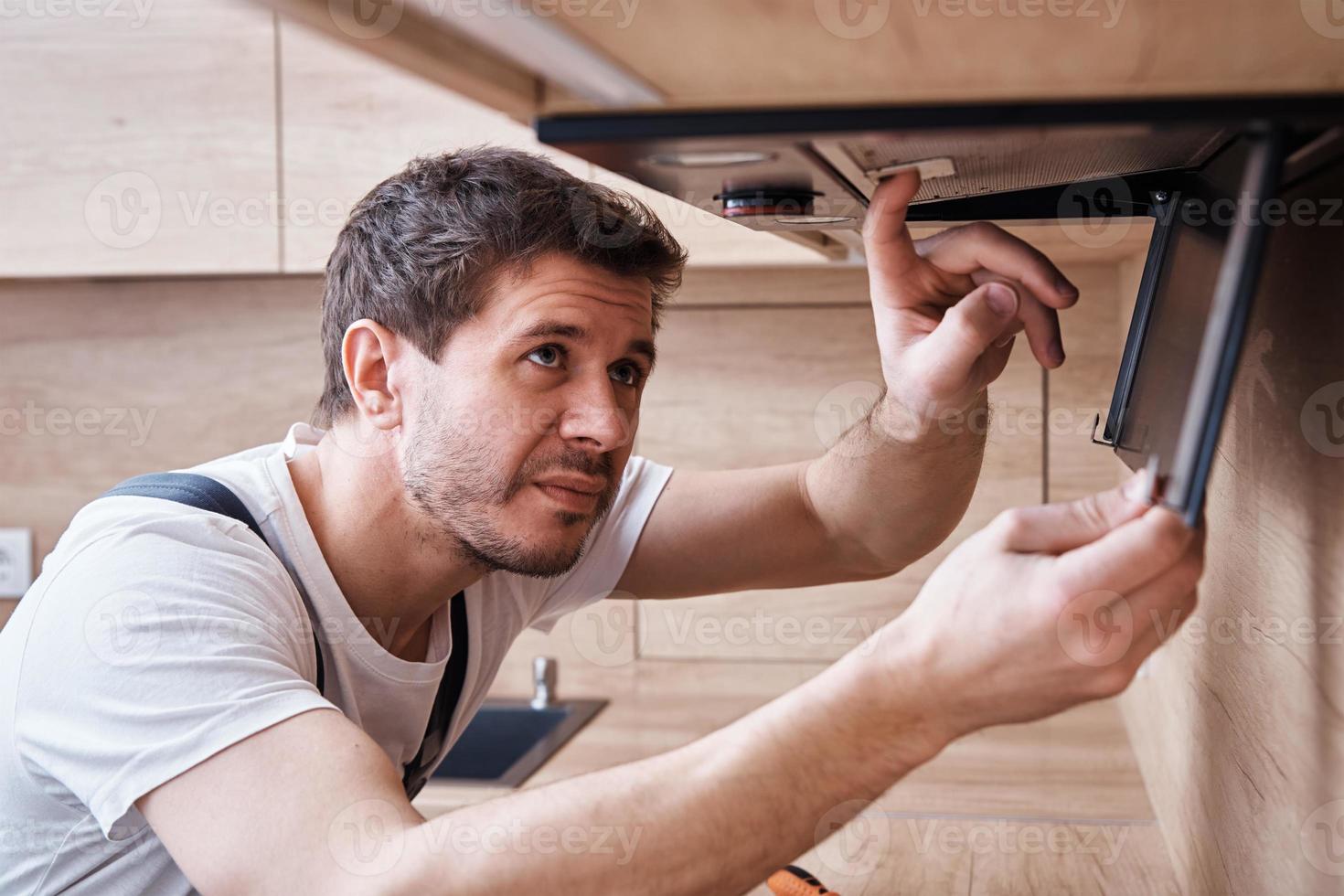 Man repairs hood in kitchen. Replacement filter in cooker hood 18911549 Stock Photo at Vecteezy