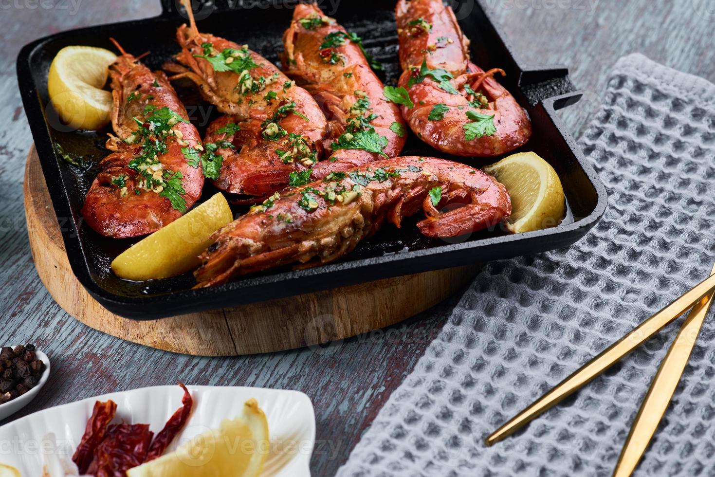 Grilled large queen shrimps with lemon and spices on the grill pan photo