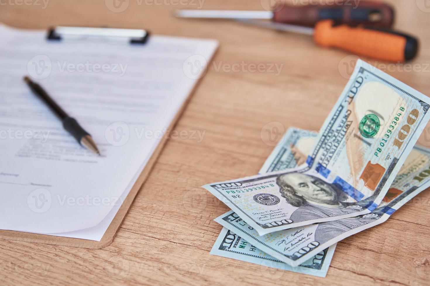 Document, pen and dollar bills on table, close up photo