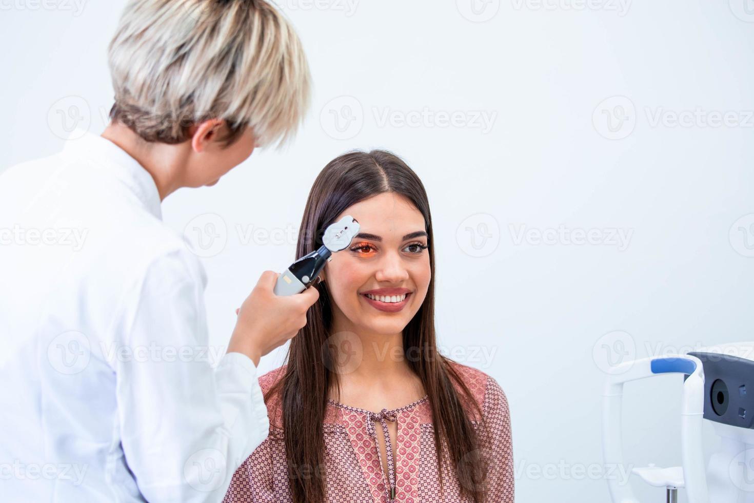 Eye health cheking with ophthalmological equipment in the laboratory. Using special device oculist trying to improve vision of young pretty girl. Working with medical devices for eye health. photo