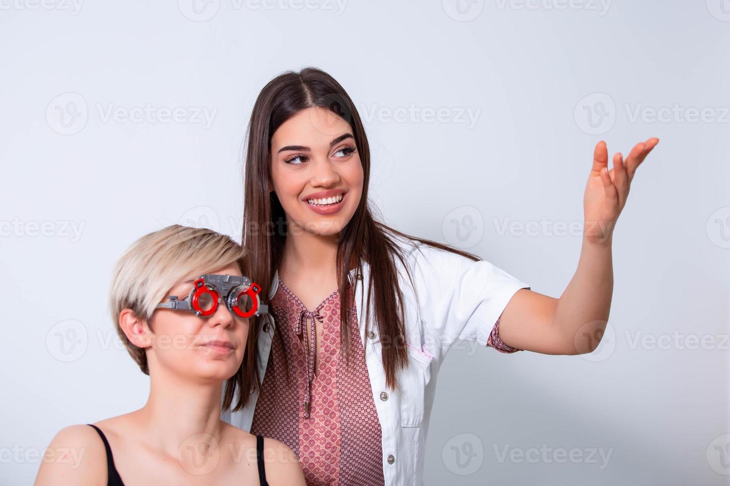 Ophthalmologist examining woman with optometrist trial frame. female patient to check vision in ophthalmological clinic photo