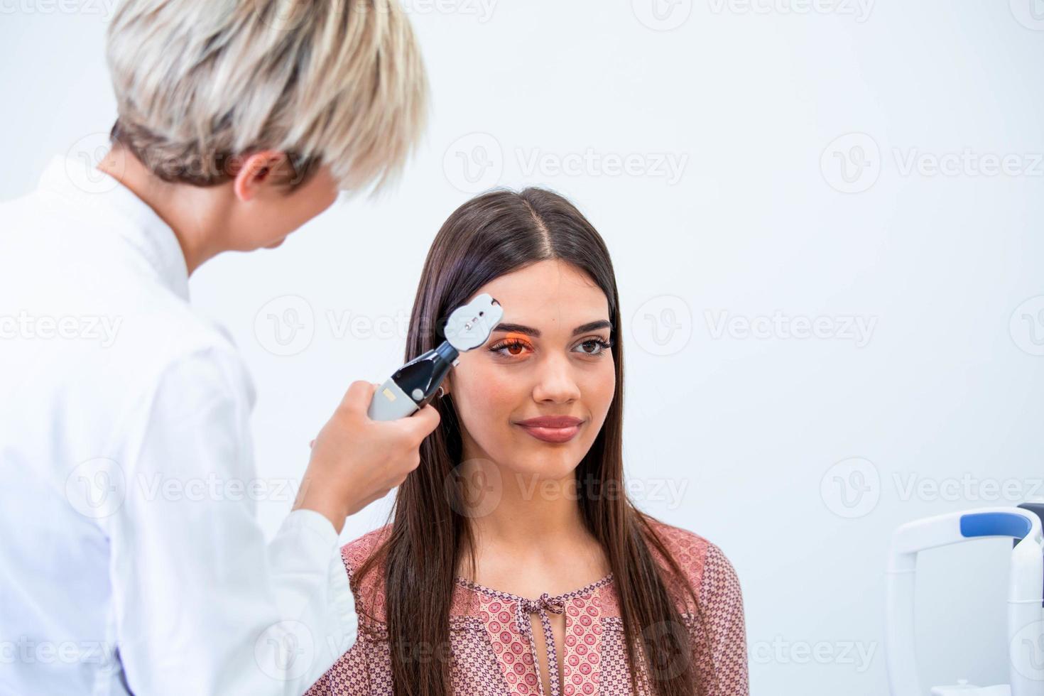 Eye health cheking with ophthalmological equipment in the laboratory. Using special device oculist trying to improve vision of young pretty girl. Working with medical devices for eye health. photo