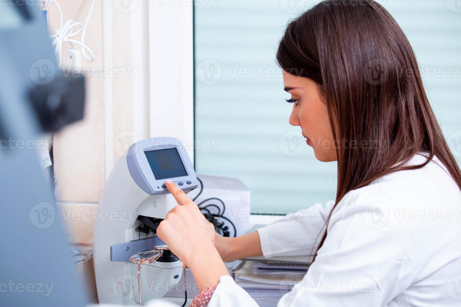 Optician repairing spectacles with tool in optical store photo