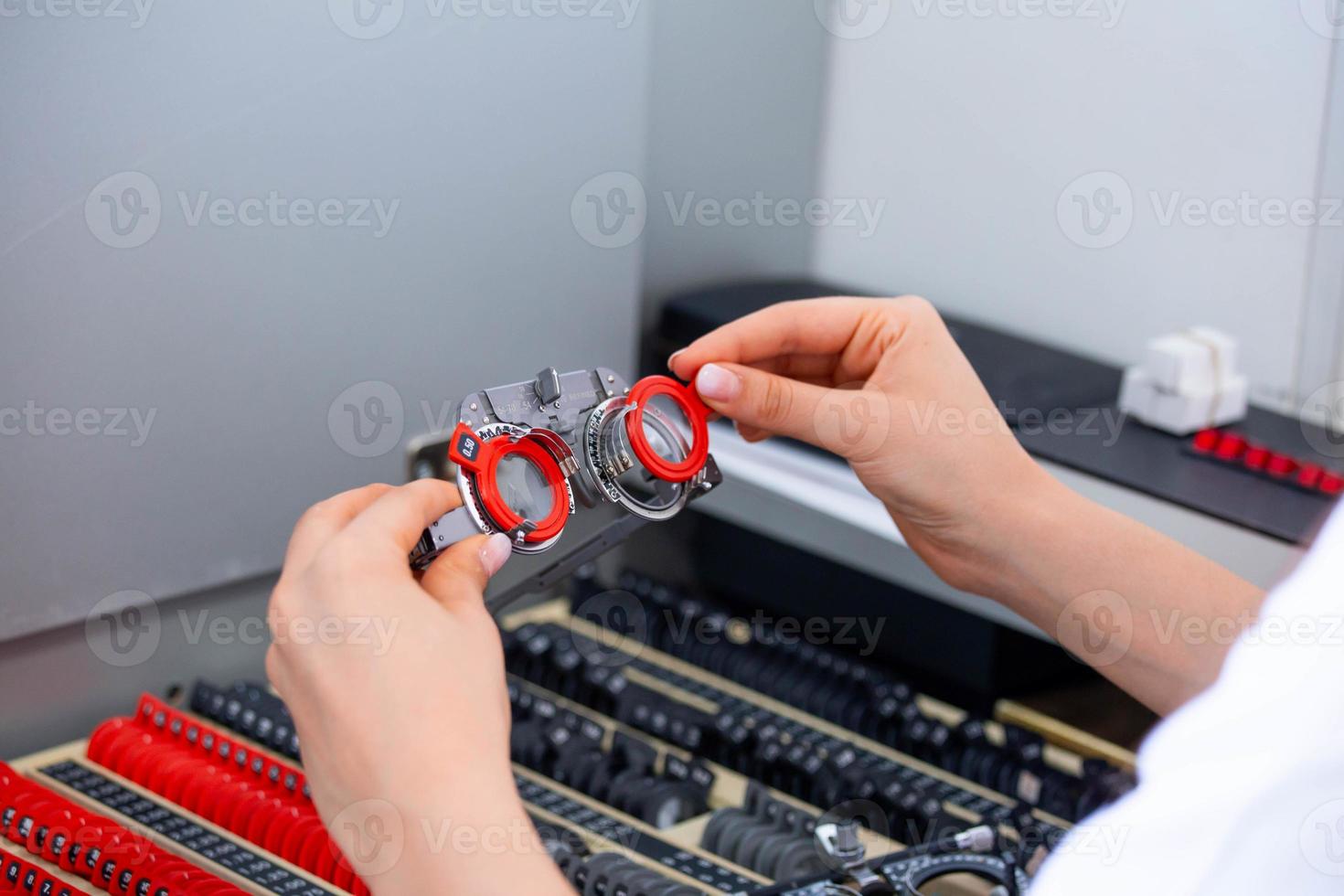 Talented skillful optician choosing lenses for trial spectacles photo