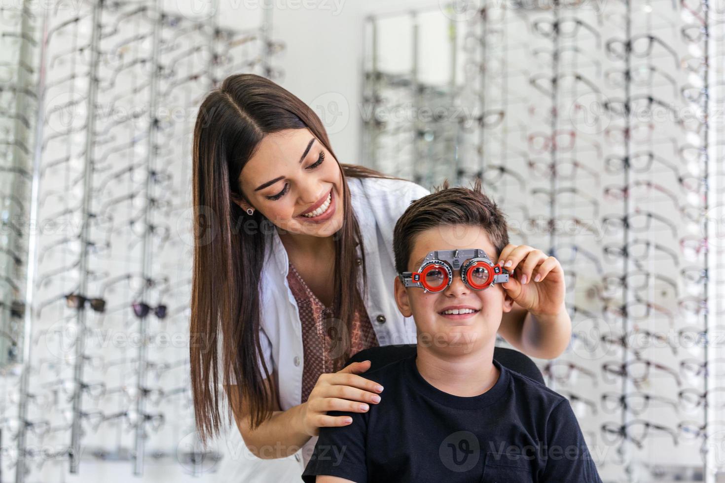 un joven sonriente está sentado y mirando la cámara durante el control de la visión. el oftalmólogo está utilizando equipos médicos especiales para salvar y mejorar la salud ocular. foto