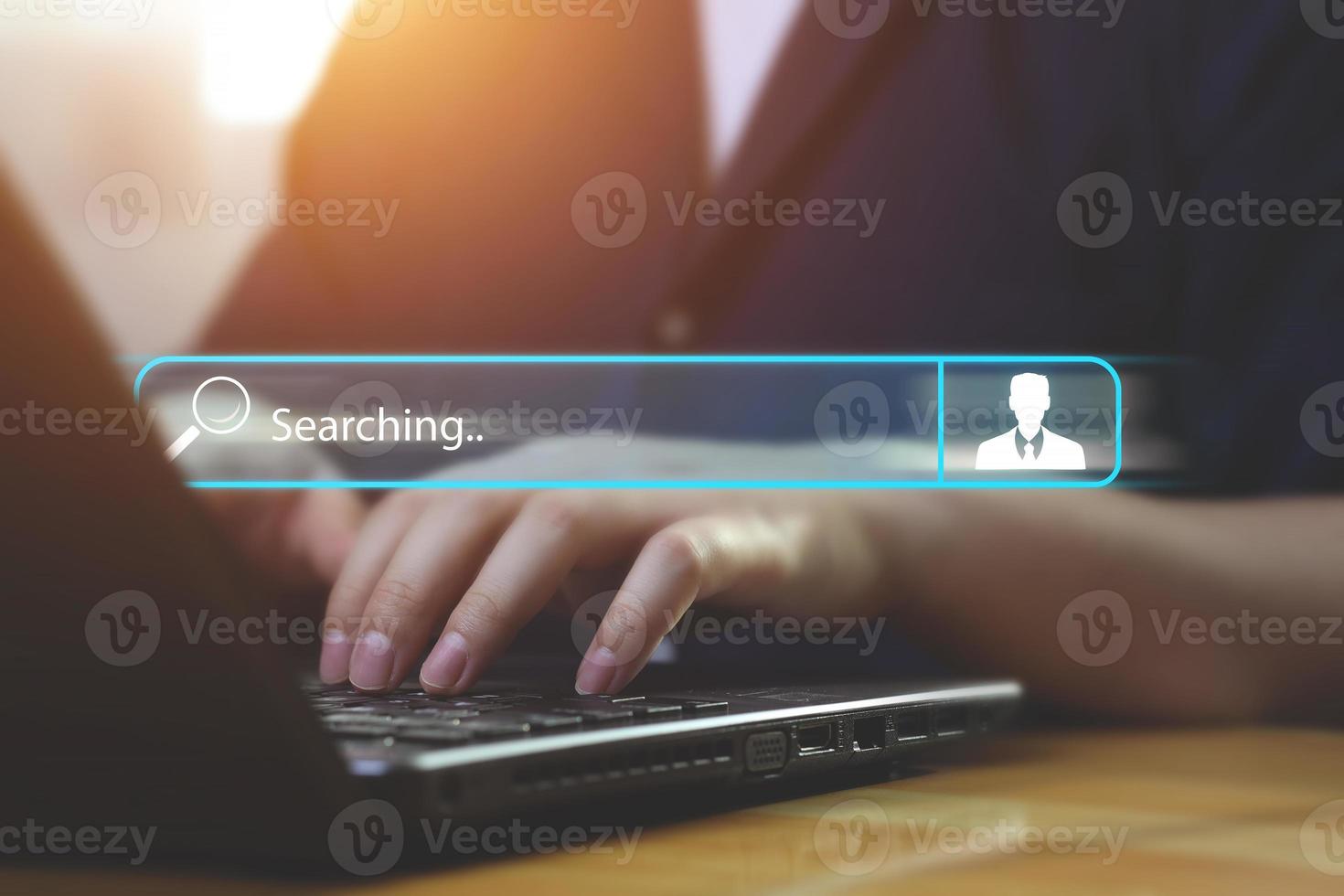 Side view man hand typing on laptop computer keyboard on table. toolbar to search for information with a human icon. Idea for web job search, corporate personal data collection, data discovery photo