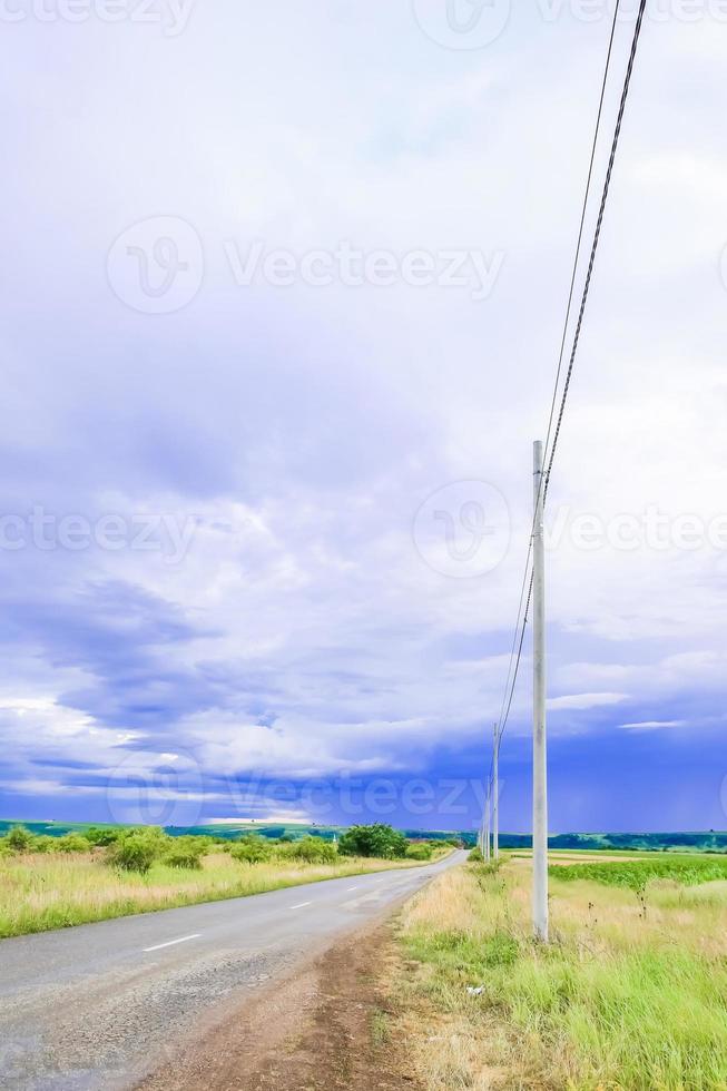 green field landscape with blue sky and stormy clouds. photo