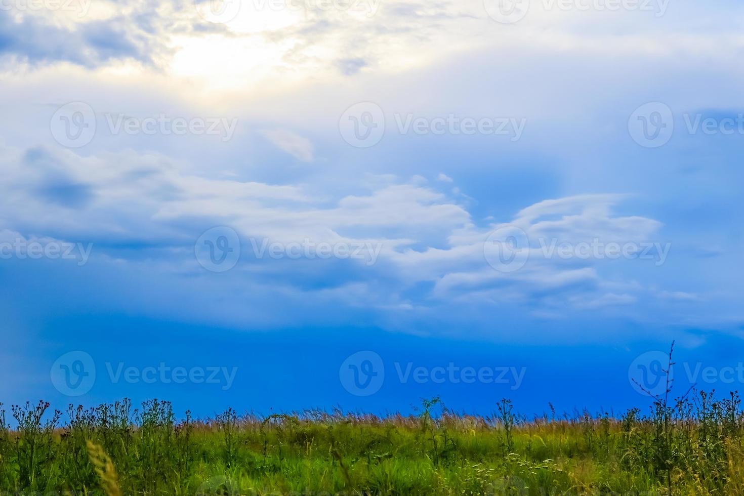 paisaje de campo verde con cielo azul y nubes tormentosas. foto