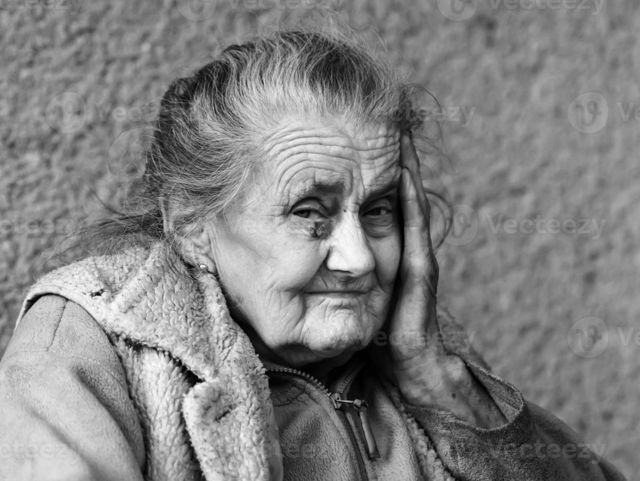 Very old and tired wrinkled woman outdoors photo