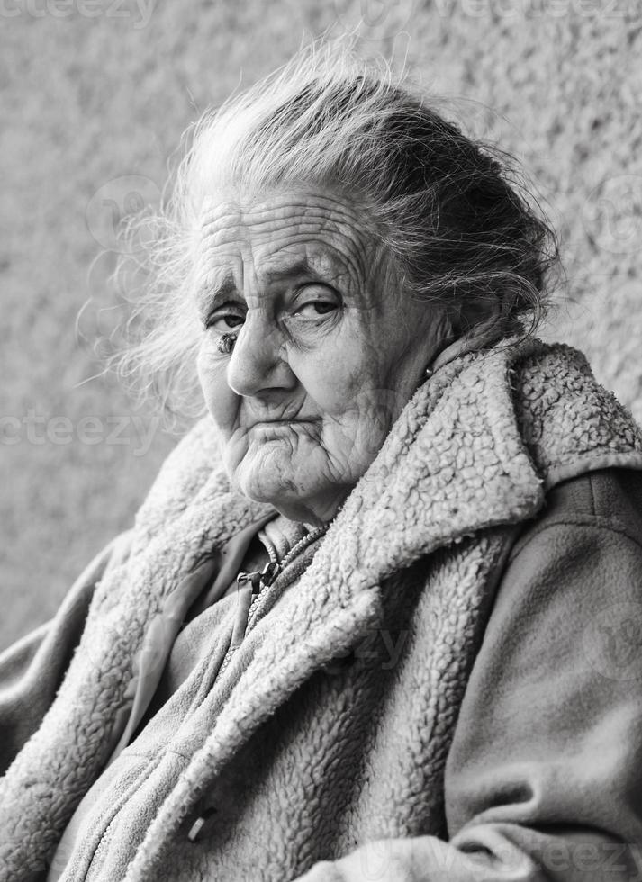 Very old and tired wrinkled woman outdoors photo