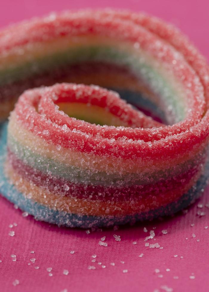 Colorful jelly candies on pink background. Selective focus. photo