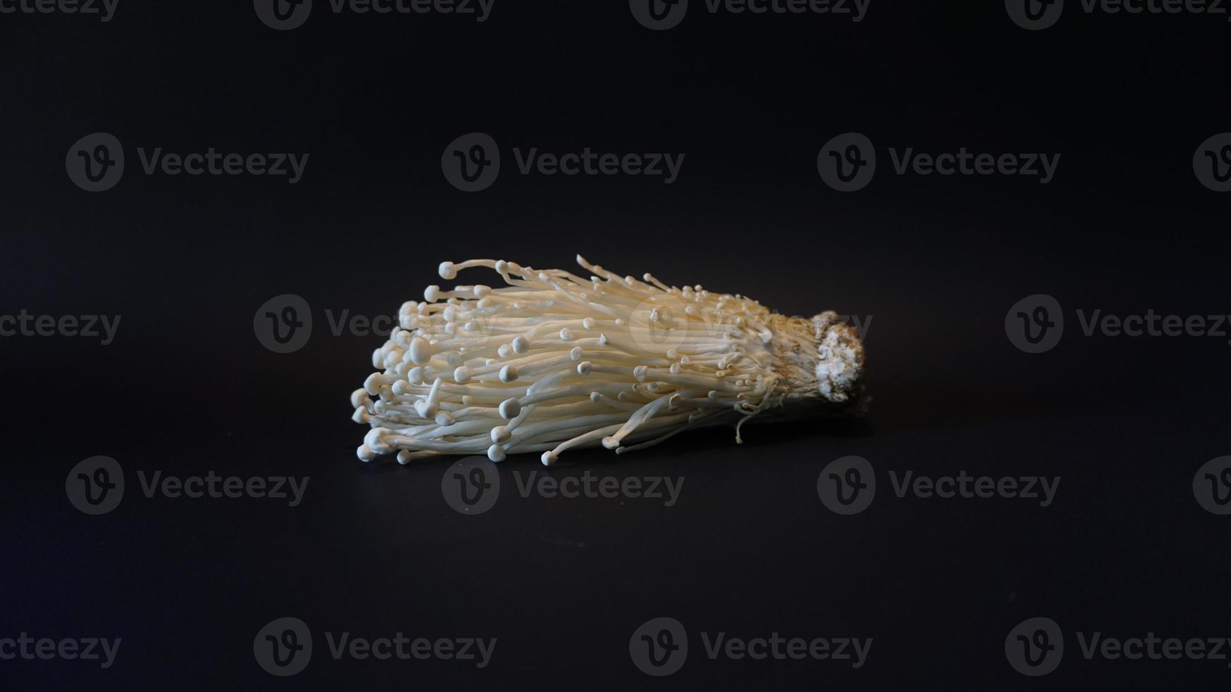 fresh enoki mushroom on black background. photo