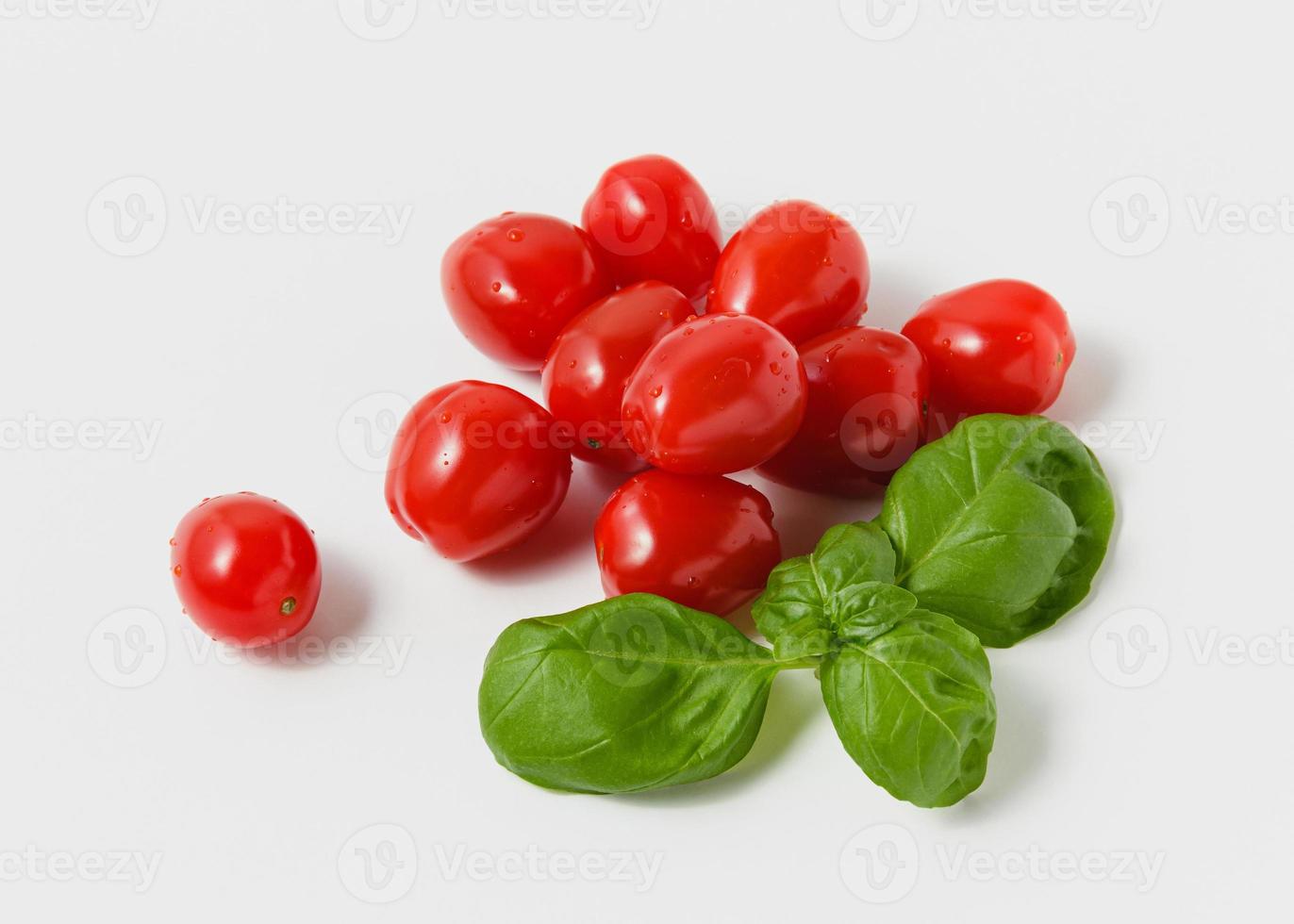 Cherry tomatoes with green basil on white background. photo