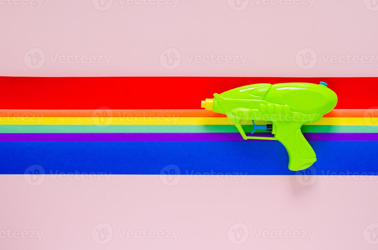 Water gun with colorful cutting paper for Songkran festival celebration on pink color background. Minimal holiday concept. photo