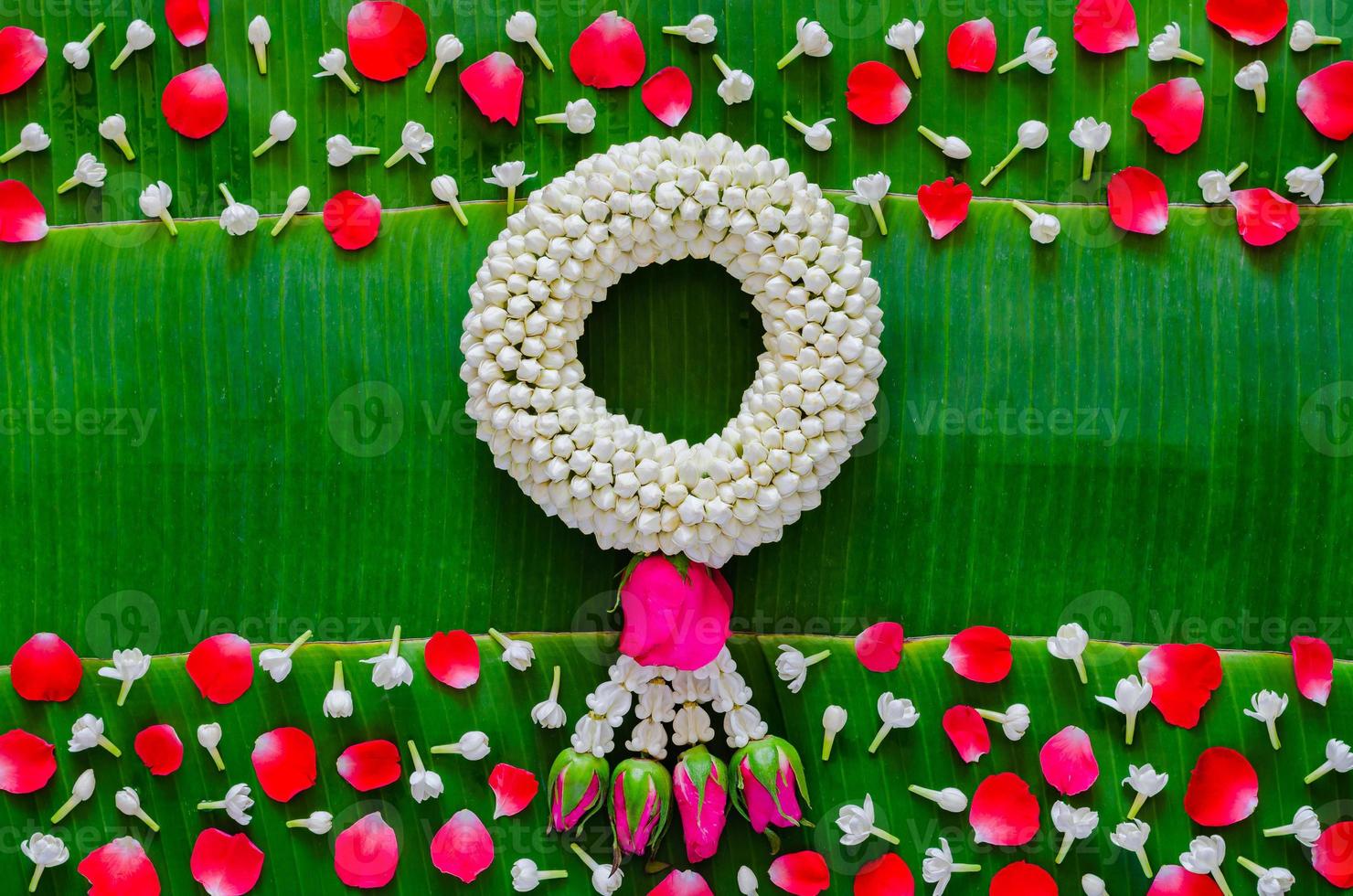 Songkran festival background with jasmine garland and flowers on banana leaf background. photo