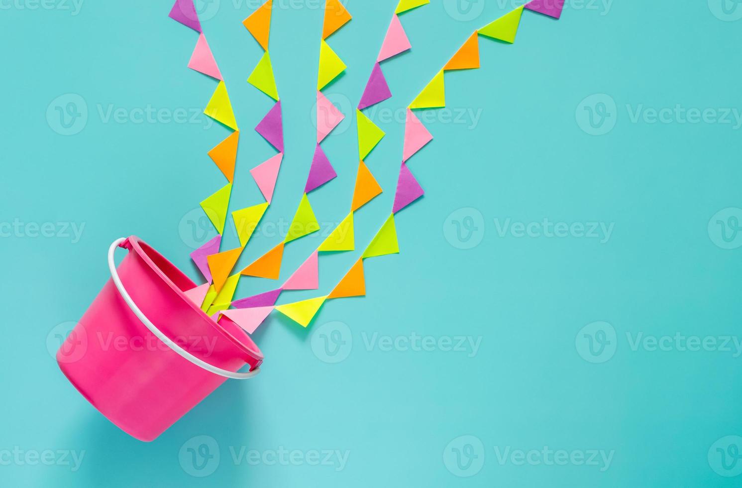 el cubo rosa salpica con una colorida bandera de fiesta que se establece como agua para la celebración del festival songkran sobre fondo azul. concepto mínimo de vacaciones. foto