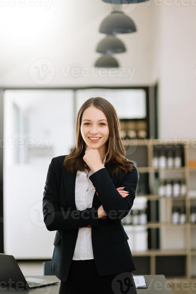 Confident female entrepreneur looking at the camera while standing. Young businesswoman standing in the boardroom of a modern office. photo