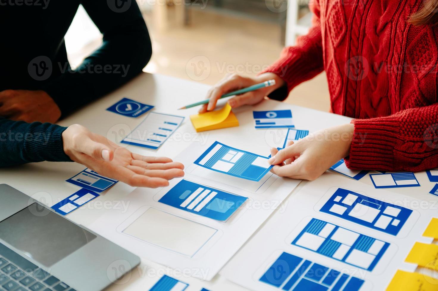 Close up view of UI developer team brainstorming on their project with laptop, smartphone and digital tablet. Creative digital development agency. photo