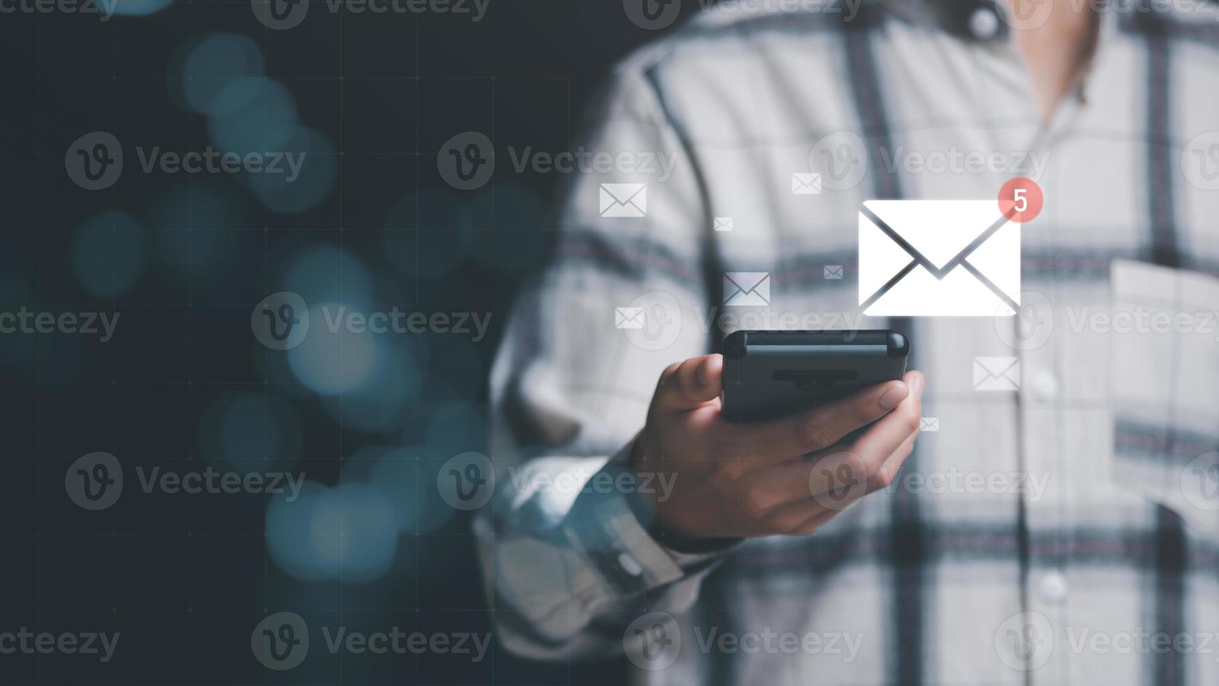 man reading electronic mail from smartphone,Email marketing and newsletter concept,Digital communication with email messages,Sending and receiving messages online with the email icon photo