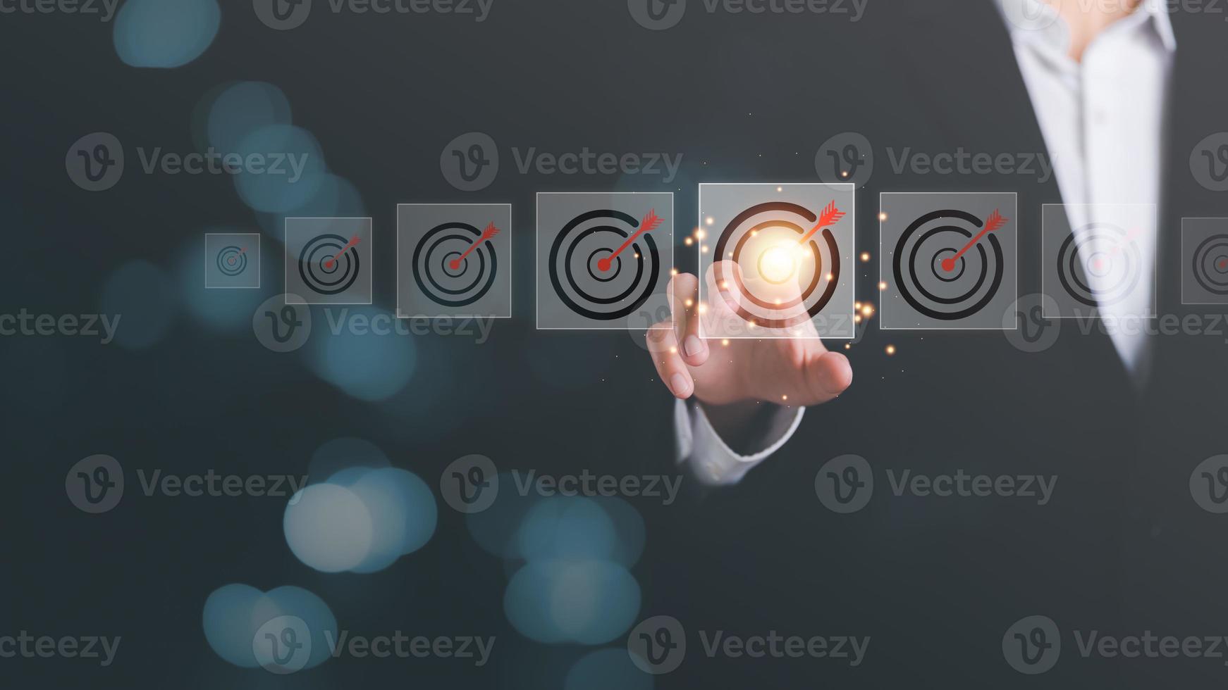 Businessman pointing arrow icon hitting center of dart board target,business goal setting,and concepts that focus on the growth of the organization according to objectives,marketing strategy planning photo