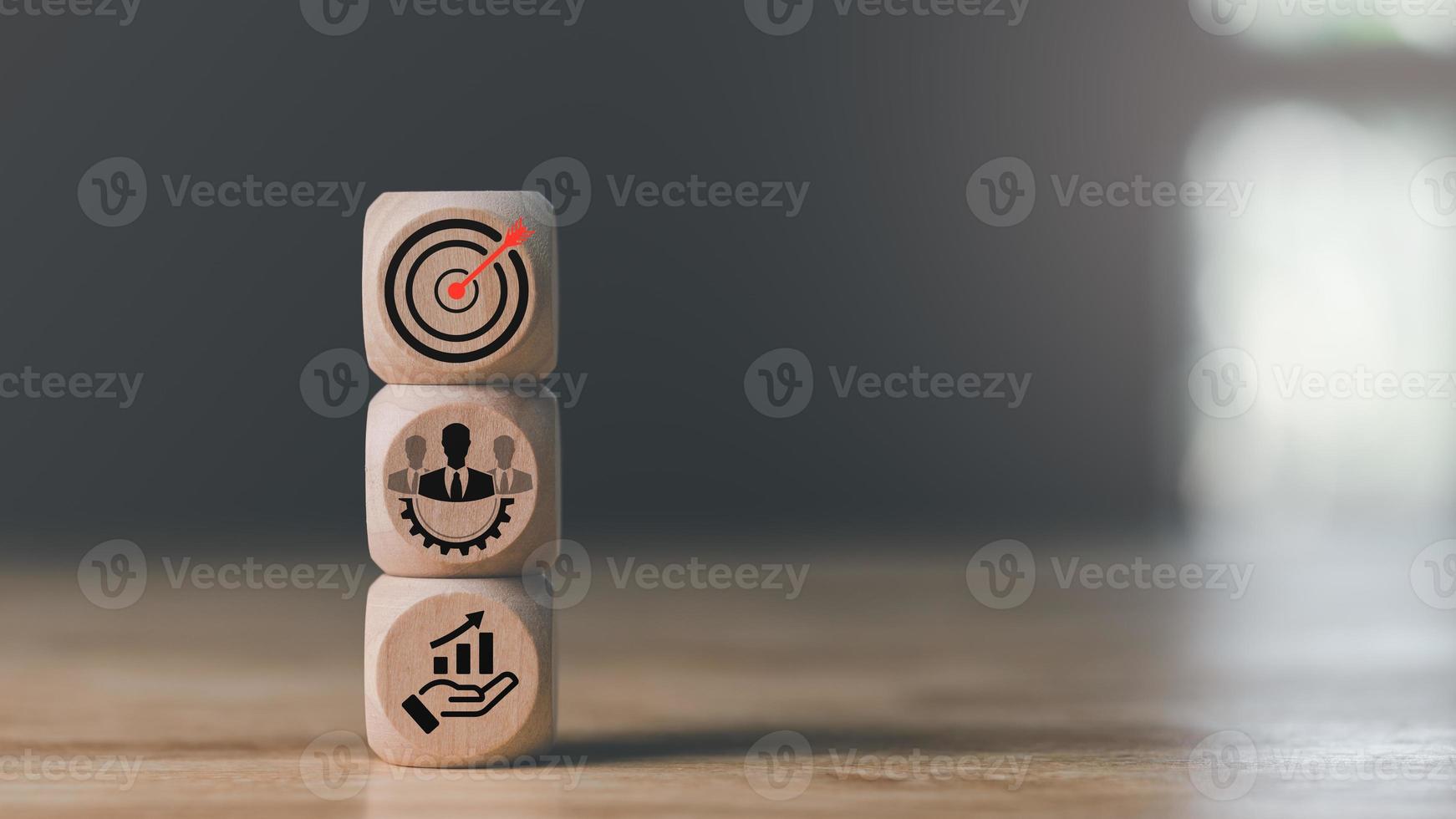 Wooden block on table, arrow icons hitting center of dart board target, set business goals and focused concept, corporate growth and objectives, marketing strategy planning photo