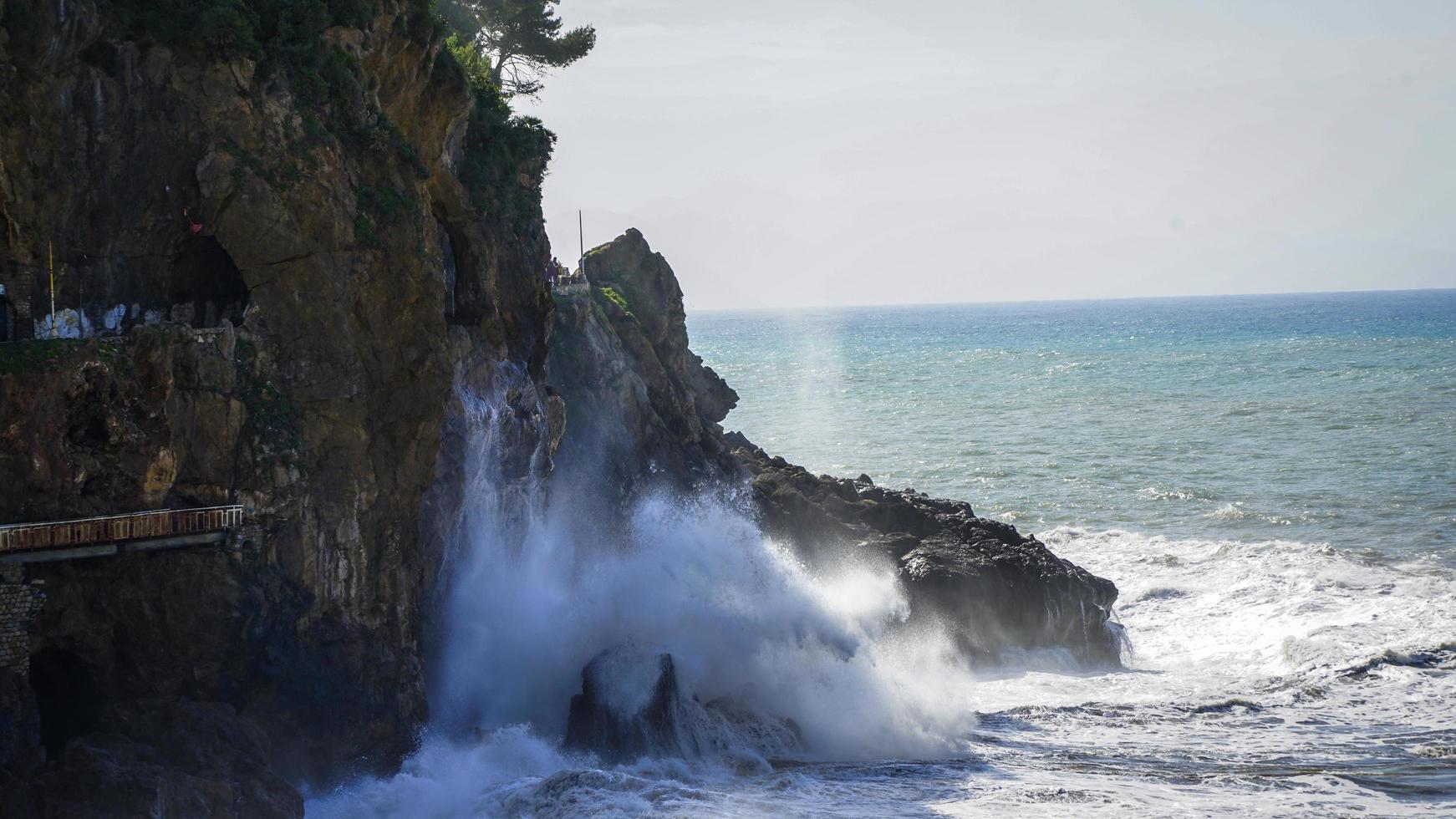 olas del mar rompiendo en las rocas foto