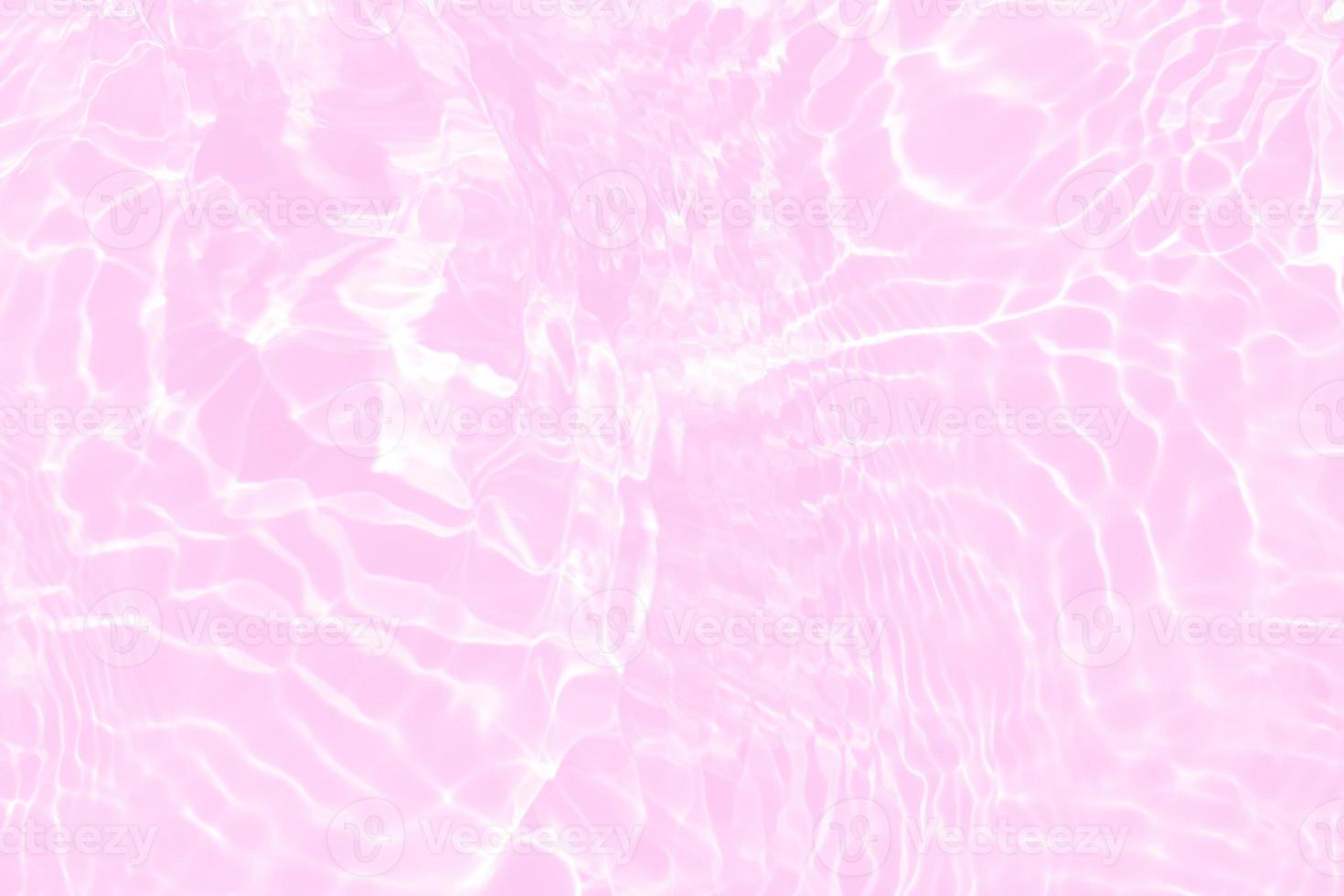 Defocus blurred transparent pink colored clear calm water surface texture with splashes and bubbles. Trendy abstract nature background. Water waves in sunlight with copy space. Pink water shine photo