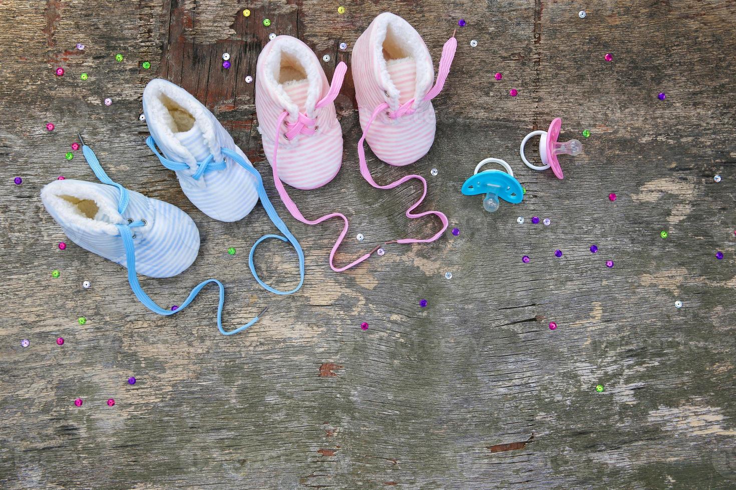 2023 new year written laces of children's shoes and pacifier on old wooden background. Top view. Flat lay. Space for text. photo
