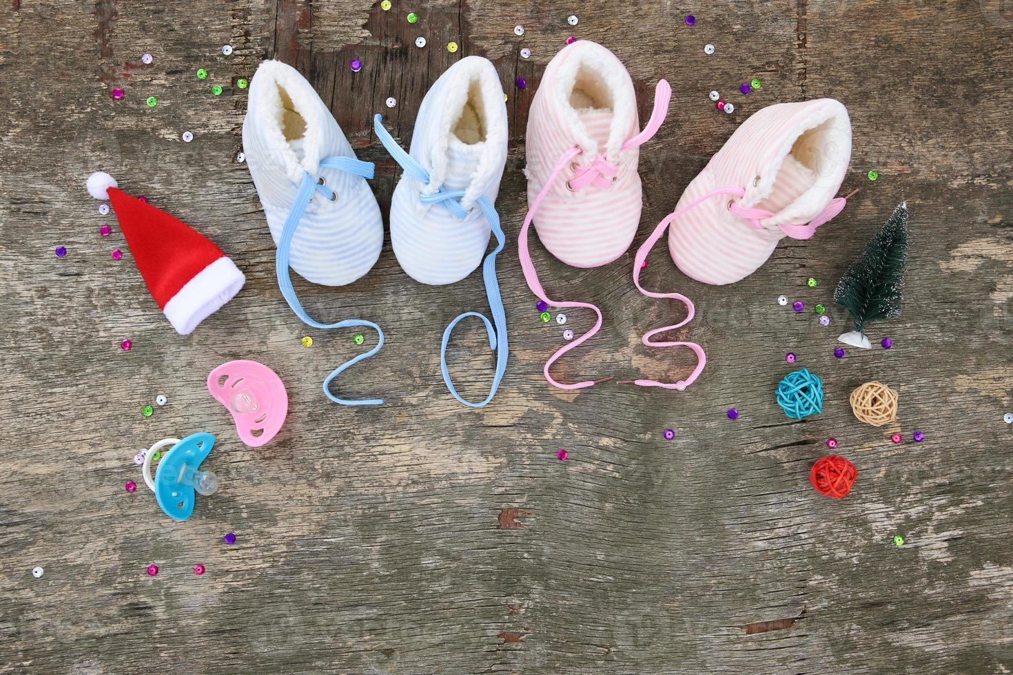 2023 new year written laces of children's shoes and pacifier on old wooden background. Top view. Flat lay. photo