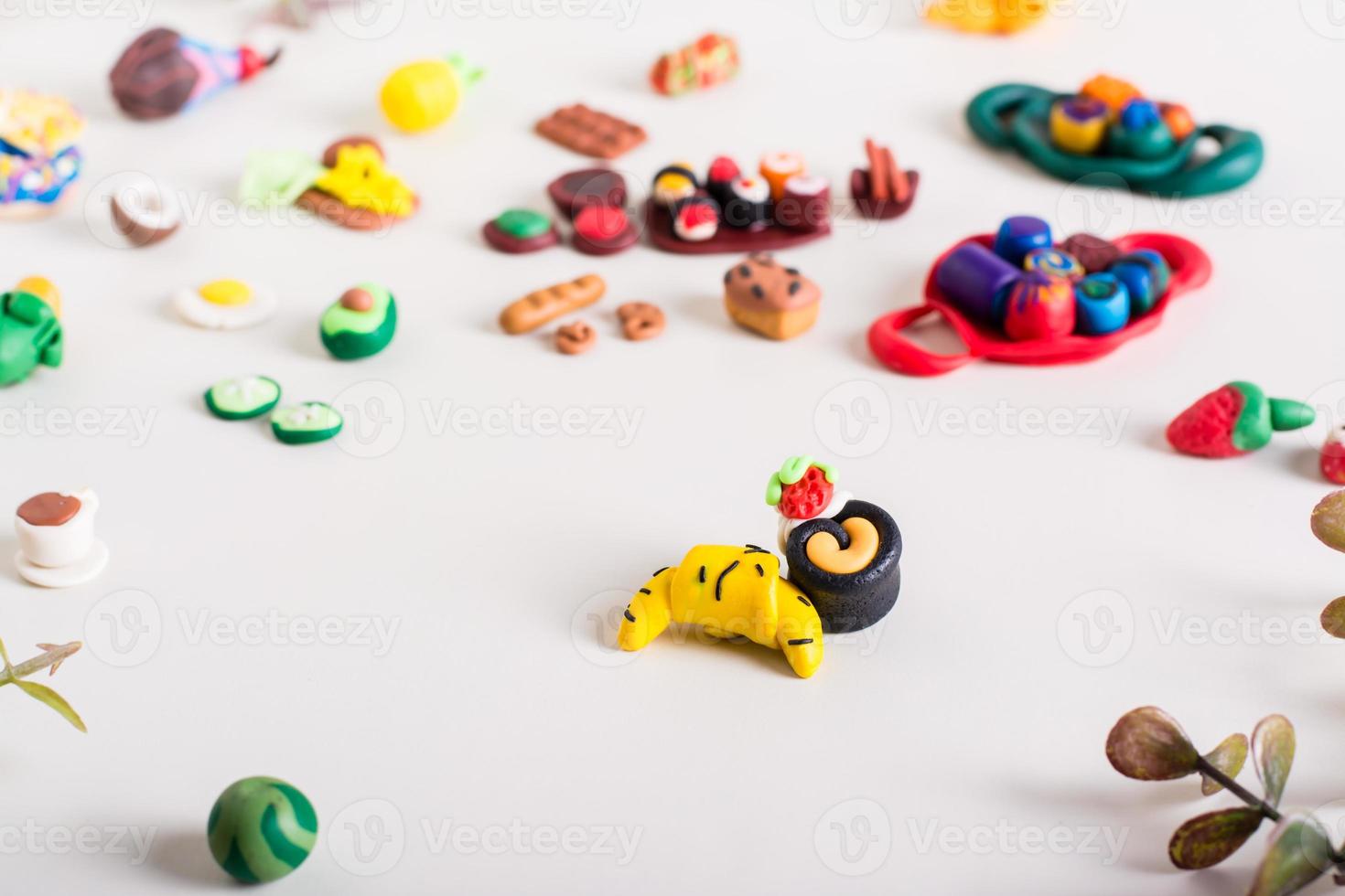 Croissant and cake and other polymer clay food on a light background. Children's leisure. photo