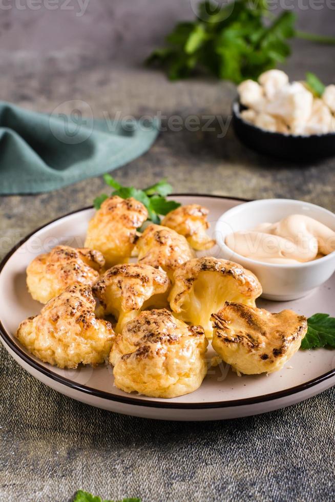 Cauliflower barbecue wings and sauce on a plate on the table. Vegetarian food. Vertical view photo