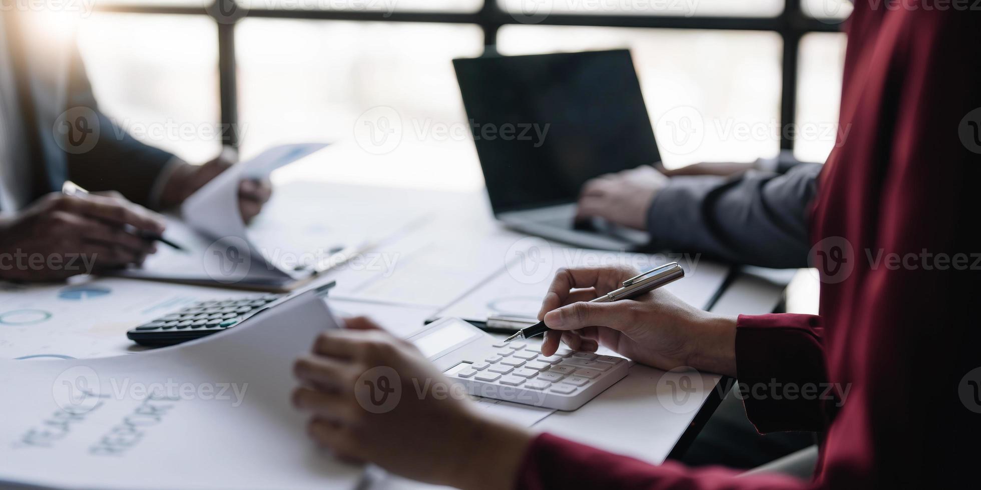 Group of confident business people point to graphs and charts to analyze market data, balance sheet, account, net profit to plan new sales strategies to increase production capacity. photo