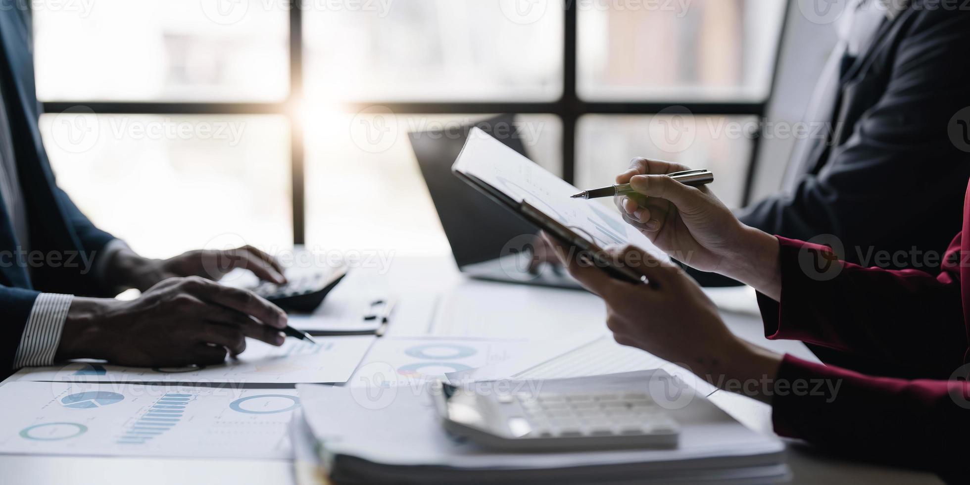 grupo de empresarios confiados señalan gráficos y cuadros para analizar datos de mercado, balance, cuenta, beneficio neto para planificar nuevas estrategias de ventas para aumentar la capacidad de producción. foto