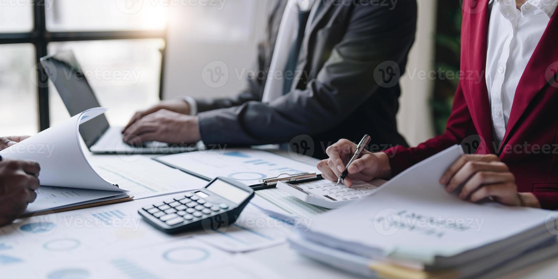 Group of confident business people point to graphs and charts to analyze market data, balance sheet, account, net profit to plan new sales strategies to increase production capacity. photo