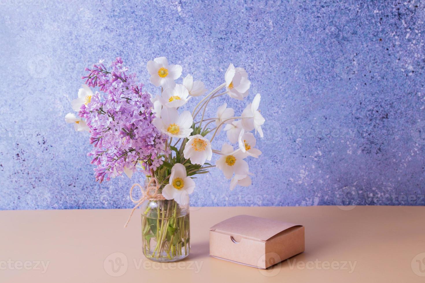 Lilac and anemones flower bouquet with gift box. Spring, Mother's Day or March 8 greeting concept. photo