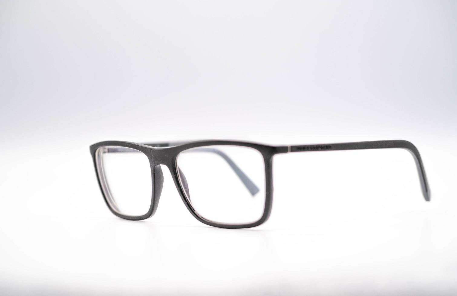black glasses with a thick rim photographed against a white background, during a photo shoot in January 2023