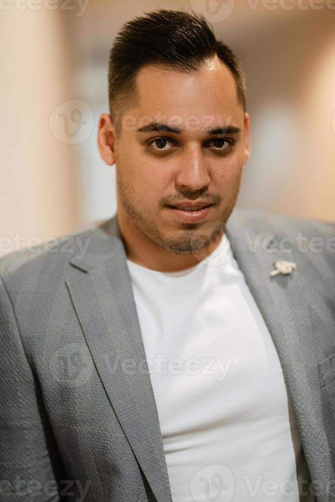 portrait of the groom in a light gray suit photo