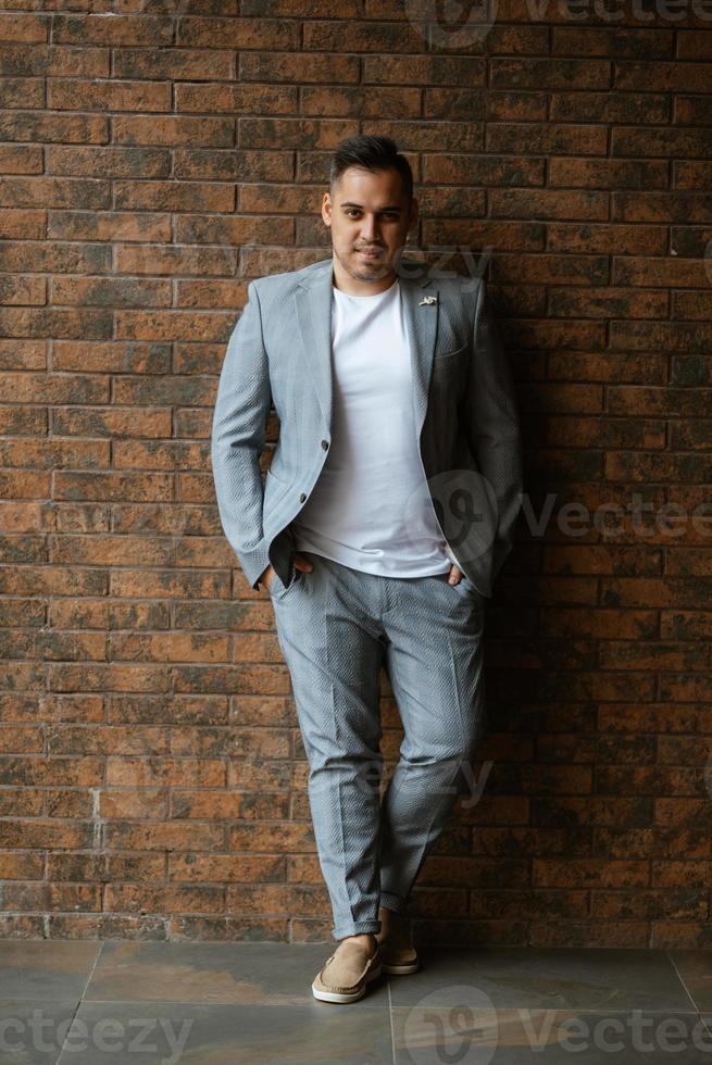 portrait of the groom in a light gray suit photo