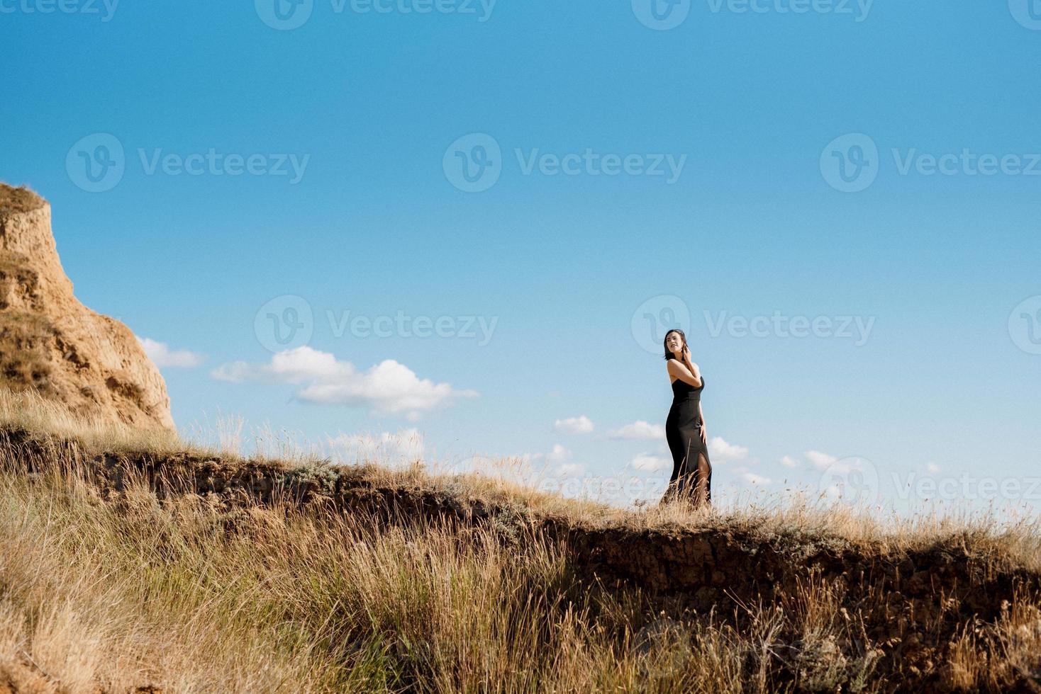 tall girl model in a black dress on the mountain hills photo