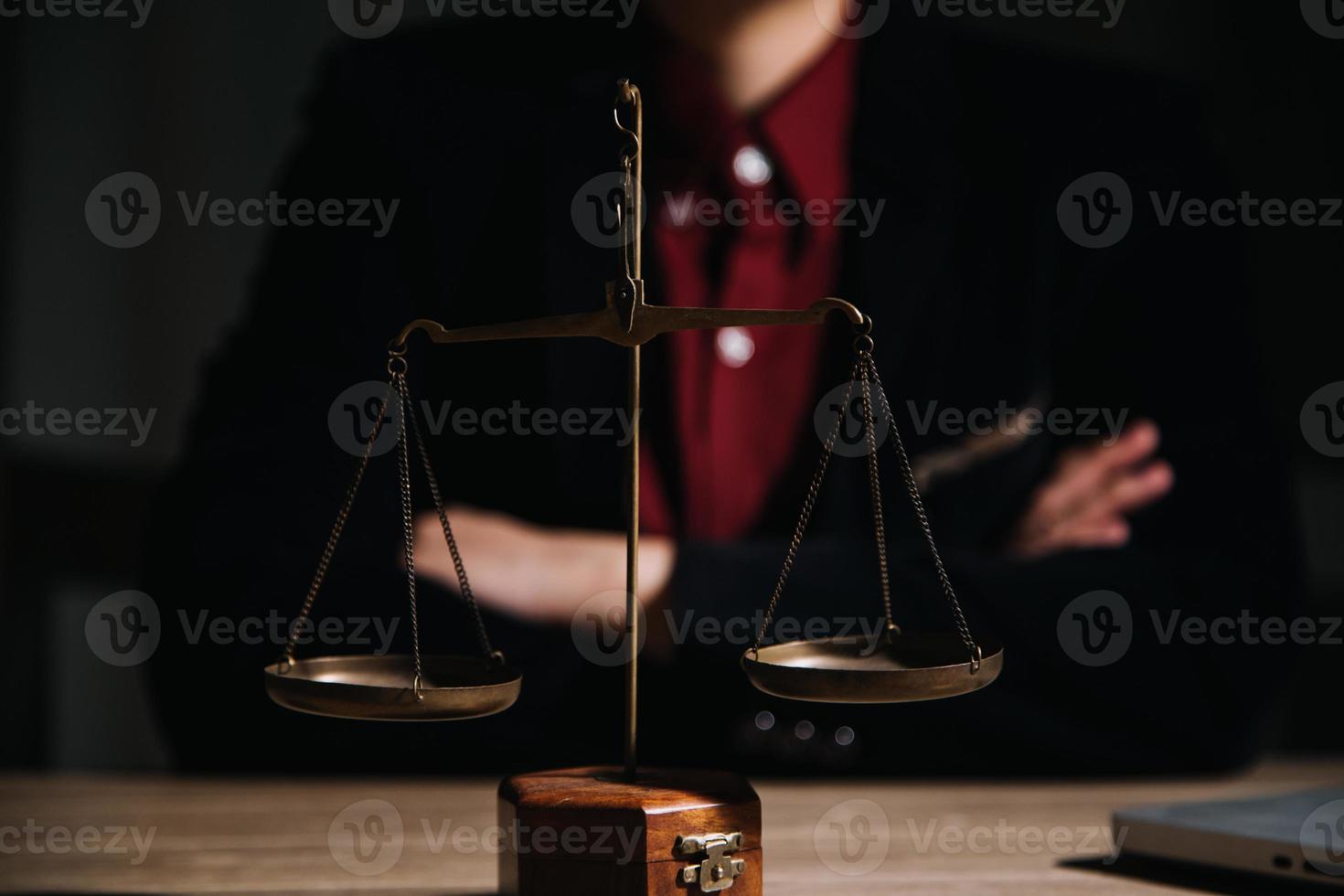 concepto de justicia y derecho. juez masculino en una sala de audiencias con el mazo, trabajando con computadora y teclado de acoplamiento, anteojos, en la mesa a la luz de la mañana foto