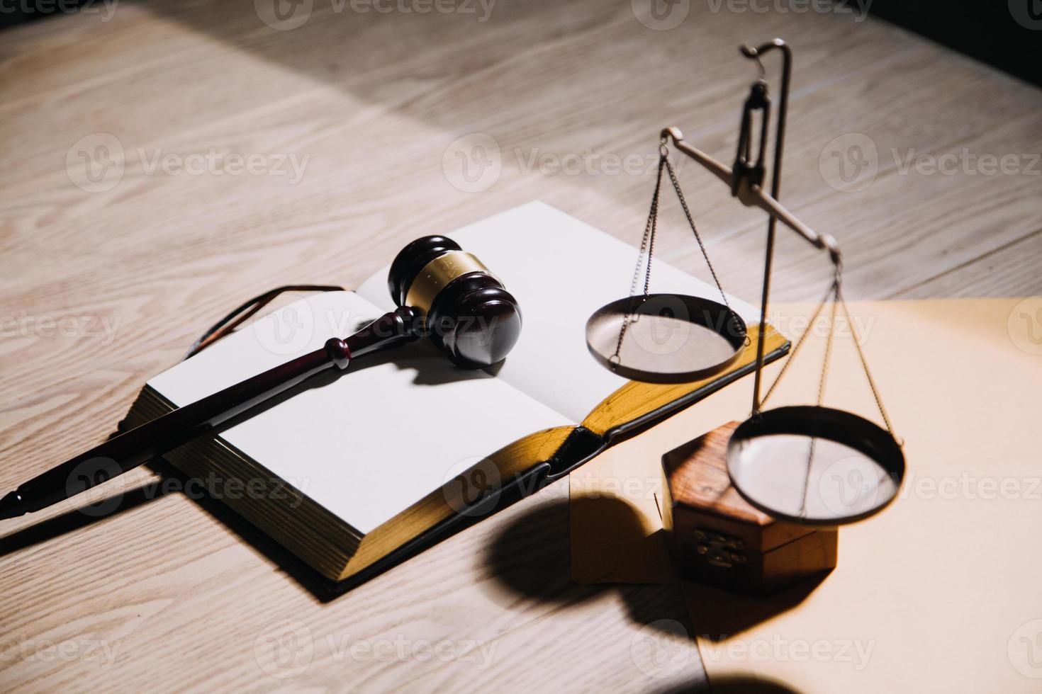 Justice and law concept.Male judge in a courtroom with the gavel, working with, computer and docking keyboard, eyeglasses, on table in morning light photo