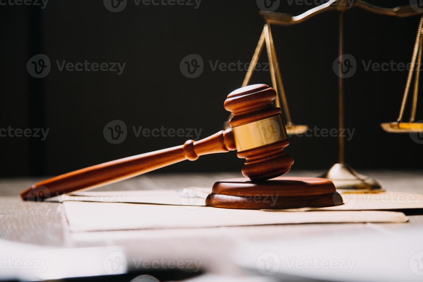 Justice and law concept.Male judge in a courtroom with the gavel, working with, computer and docking keyboard, eyeglasses, on table in morning light photo