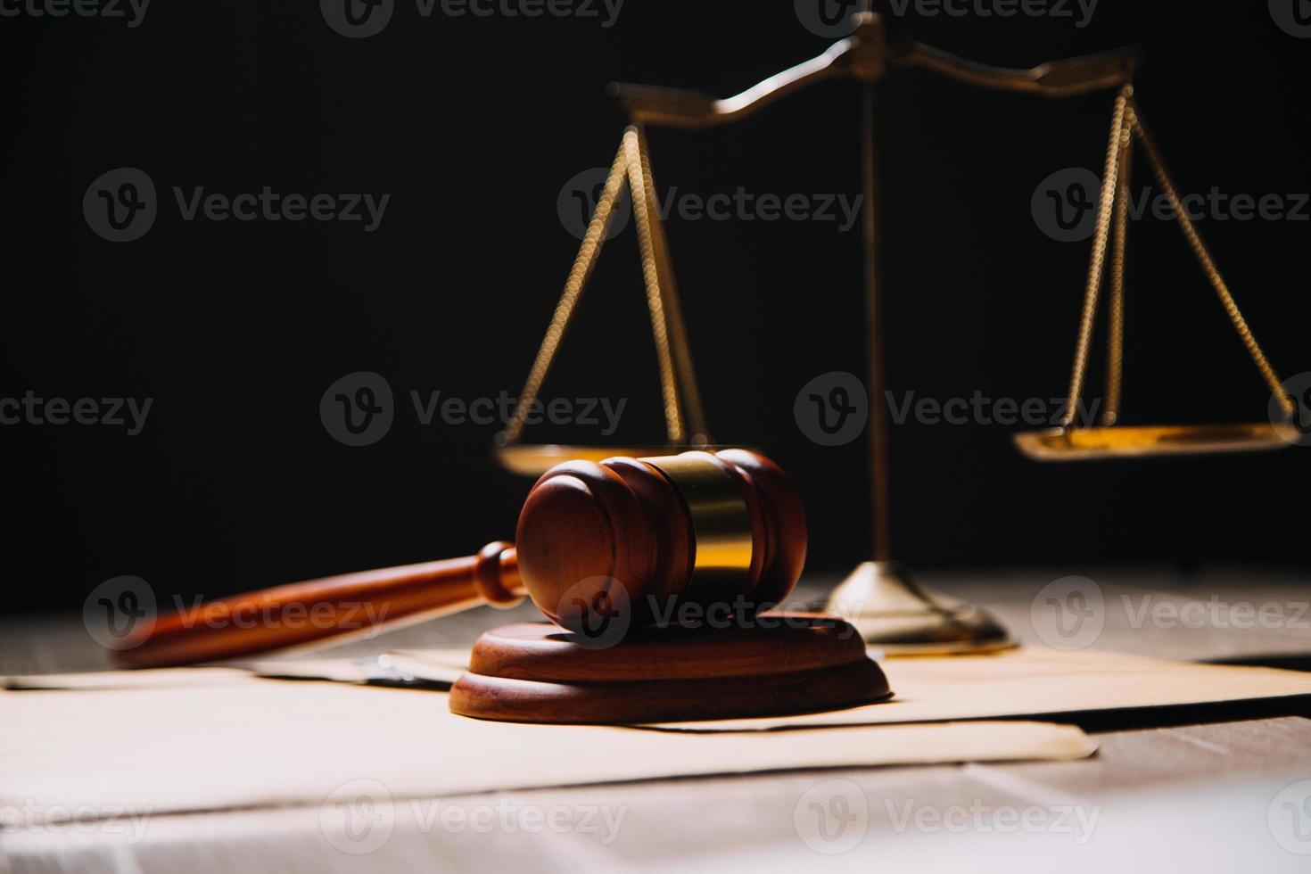 Justice and law concept.Male judge in a courtroom with the gavel, working with, computer and docking keyboard, eyeglasses, on table in morning light photo