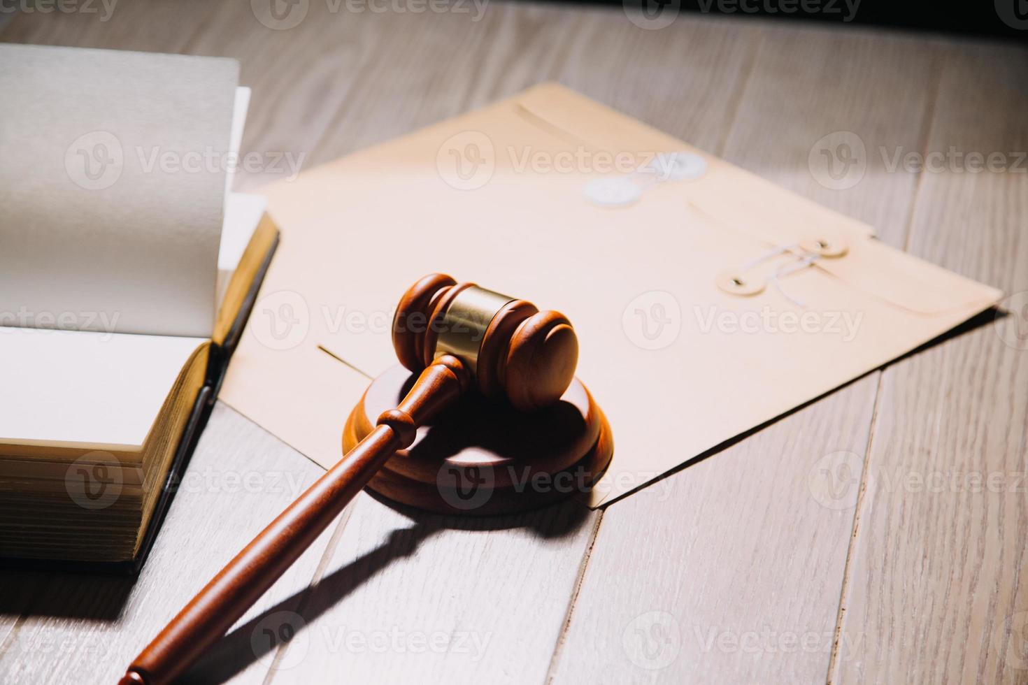 Justice and law concept.Male judge in a courtroom with the gavel, working with, computer and docking keyboard, eyeglasses, on table in morning light photo