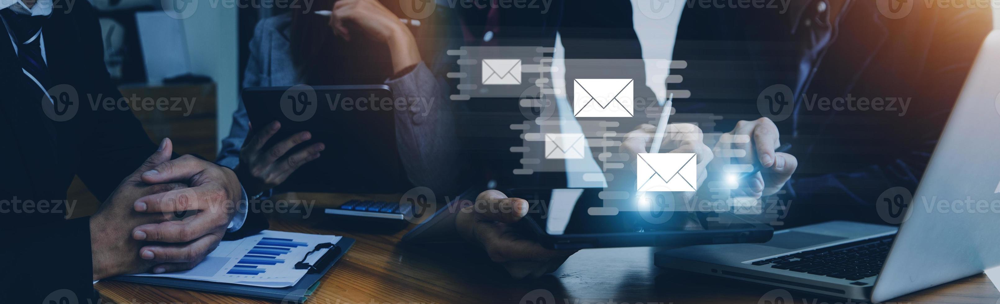 Businessman hands using Laptop typing on keyboard and surfing the internet on office table with email icon, email marketing concept, send e-mail or newsletter, online working internet network. photo