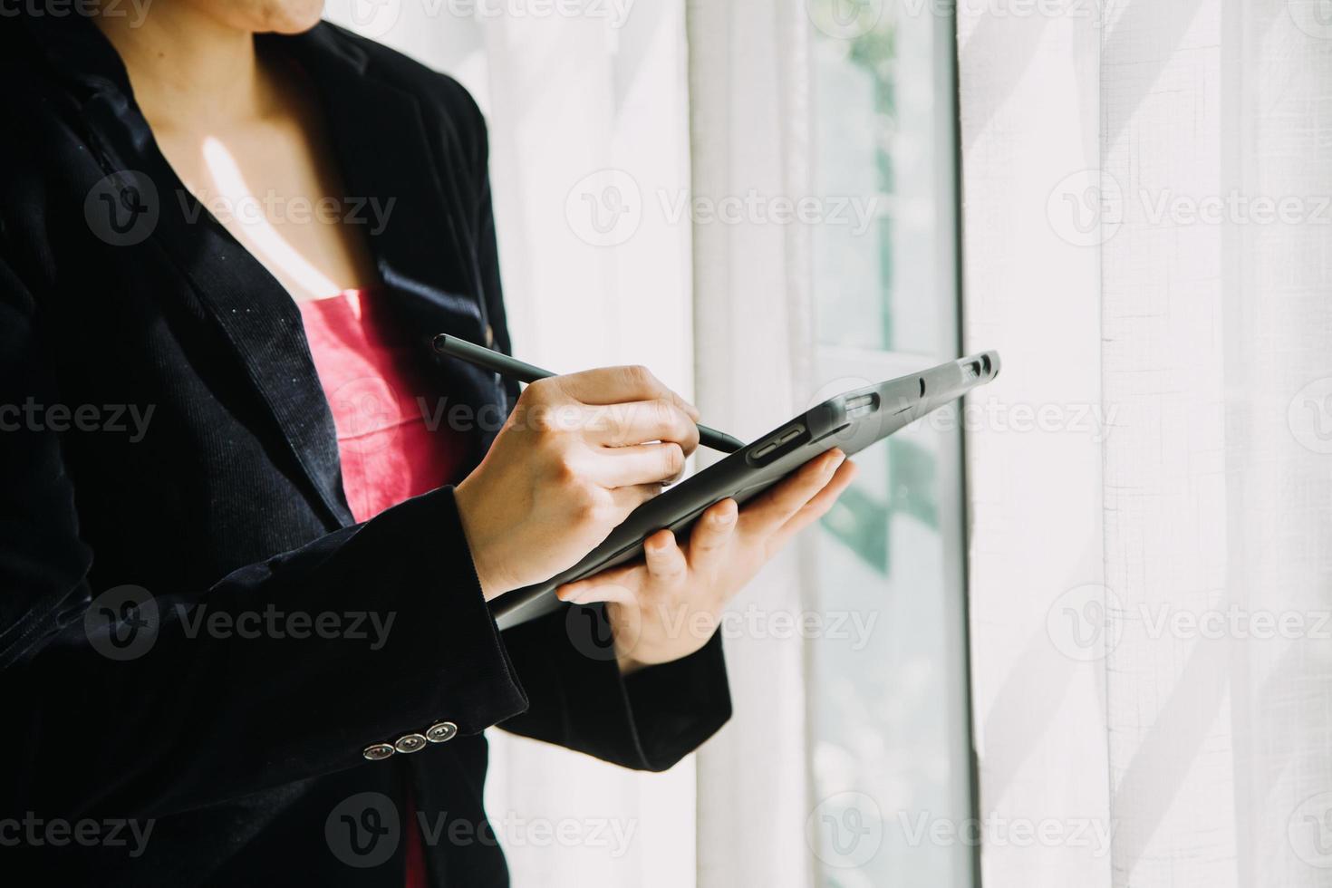 Mature businessman using a digital tablet to discuss information with a younger colleague in a modern business lounge photo