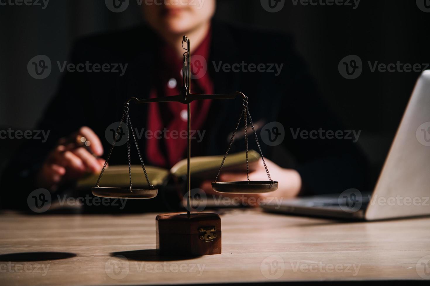 concepto de justicia y derecho. juez masculino en una sala de audiencias con el mazo, trabajando con computadora y teclado de acoplamiento, anteojos, en la mesa a la luz de la mañana foto